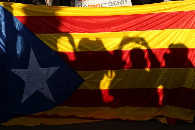 Silhouettes of media are projected in an Estelada (Catalan separatist flag) during a lawyers and attorneys protest outside of Catalonia's Supreme Court in support for the banned October 1 independence referendum in Barcelona, Spain, September 27, 2017. REUTERS/ (Albert Gea/Reuters)