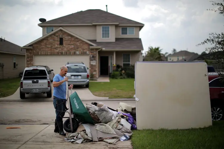 Homem limpa estragos causados pelo furacão Harvey (Carlos Barria/Reuters)