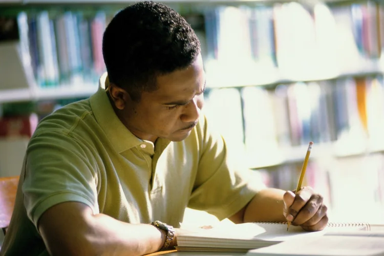 Homem estudando em biblioteca (Ingram Publishing/Thinkstock)