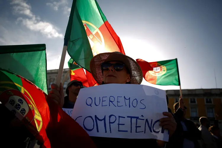 Mulher segura cartaz de protesto que pede competência ao governo português  (Pedro Nunes/Reuters)