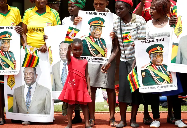 Criança e mulheres comemoram a posse do novo presidente do Zimbábue, Emmerson Mnangagwa, dia 24/11/2017 (Siphiwe Sibeko/Reuters)