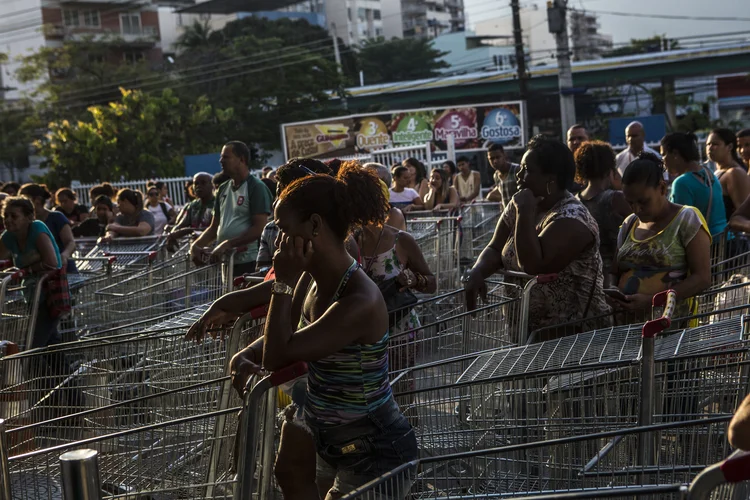 Consumidores com carrinhos esperam em fila para descontos do Supermercado Guanabara no Rio de Janeiro (Dado Galdieri/Bloomberg)