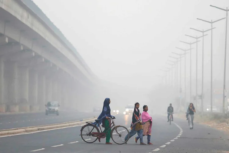 Pessoas atravessam uma rua em Nova Déli, na Índia, em 07.11.2017. (Saumya Khandelwal/Reuters)