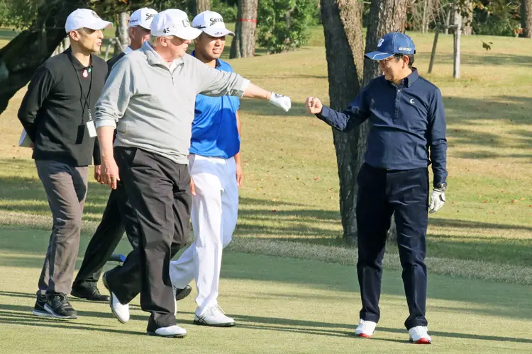 Donald Trump e Shinzo Abe jogam golfe com o jogador profissional Hideki Matsumaya em Tóqui, Japão: líder republicano destacou a importância estratégica da aliança com Japão (Japan's Cabinet Public Relations Office via Kyodo/Reuters)