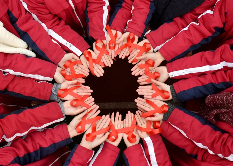 Pessoas seguram fita que simboliza luta contra a aids: pela segunda vez na história, pessoa pode ter sido curada de infecção com HIV (Divulgação/Reuters)