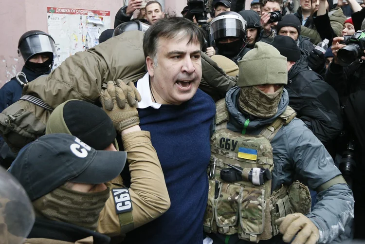Prisão: várias pessoas reunidas no local tentaram impedir a passagem do veículo que levava o ex-presidente (Valentyn Ogirenko/Reuters)