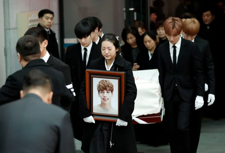 Membros da banda SHINee carregam caixão do colega Kim Jong-hyun: sua irmã carregava uma fotografia de um sorridente Kim (Kim Hong-Ji/Reuters)