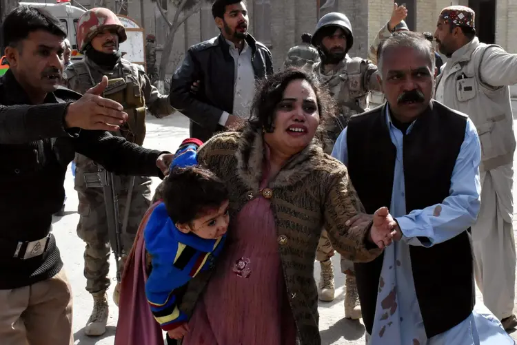 Policial guia família após ataque em de Igreja Metodista em Quetta, Paquistão: agência não forneceu evidências para sustentar a reivindicação de autoria (Naseer Ahmed/Reuters)