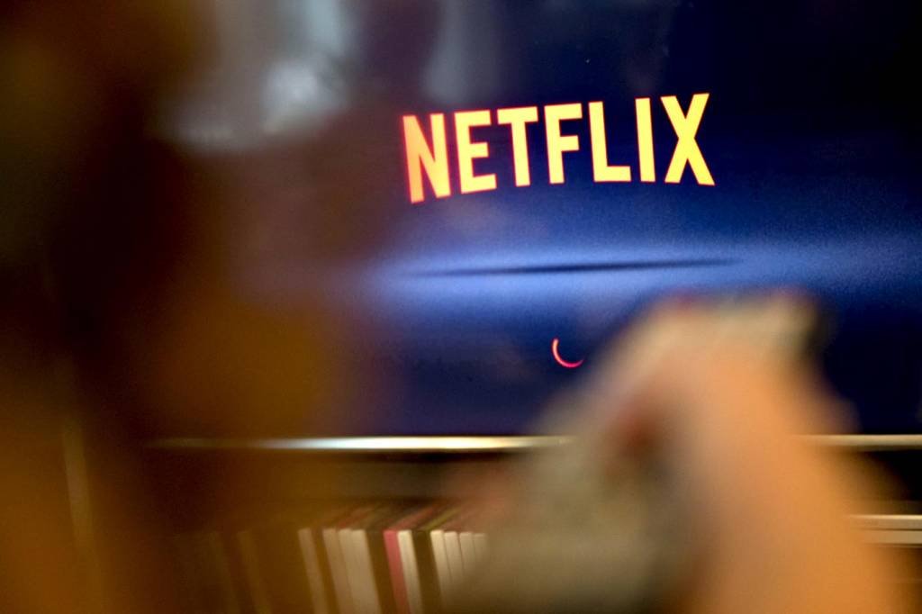 Pessoa assiste à Netflix na televisão (Daniel Acker/Bloomberg)