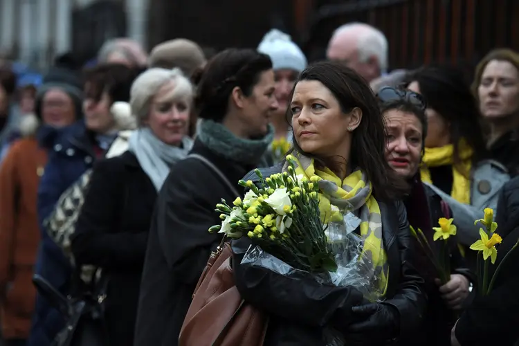 Amigos e parentes com flores amarelas no enterro da cantora Dolores O'Riordan, em Limerick (Clodagh Kilcoyne/Reuters)