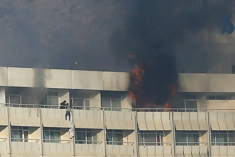 Homem tenta escapar de sacada de do Hotel Intercontinental em Cabul, Afeganistão: todos os cinco atiradores também foram mortos, disse o porta-voz do Ministério do Interior (Omar Sobhani/Reuters)