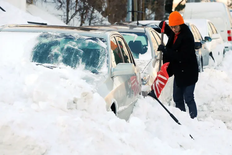 Mulher retira neve do seu carro em Boston: cidade sofre com escassez de encanadores para consertar canos e tubulações que congelaram (Brian Snyde/Reuters)