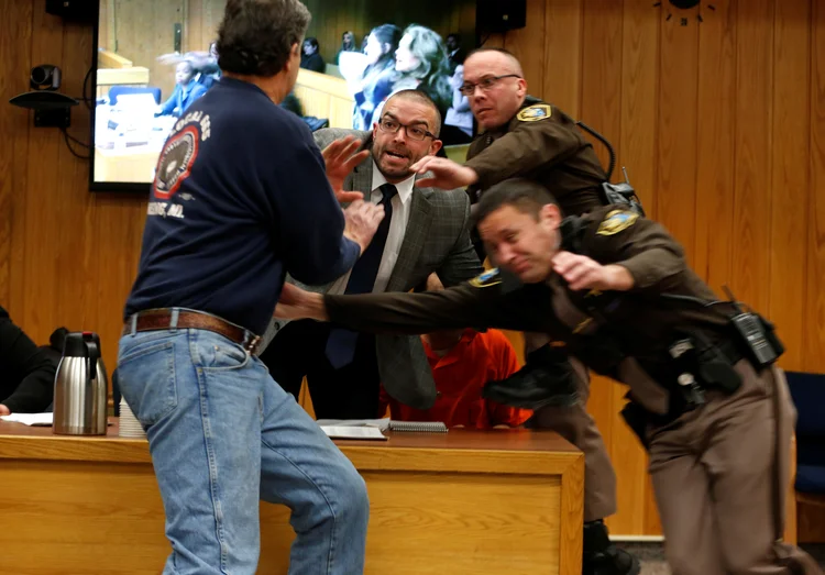 Randall Margraves (E) tenta agredir ex-médico Larry Nassar em tribunal (Rebecca Cook/Reuters)