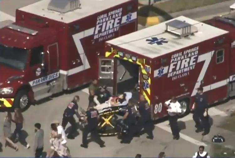 Trabalhadores de resgate se preparam para transportar uma vítima em uma maca perto de escola após tiroteio em Parkland, Flórida, EUA. (Reprodução/Reuters)