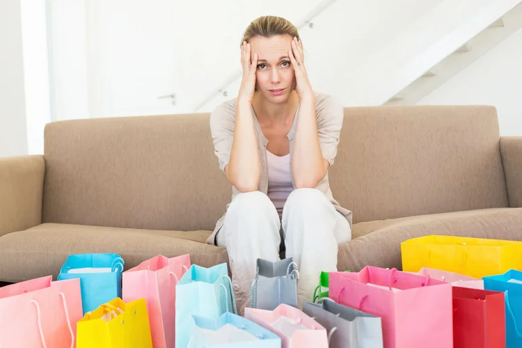 Mulher arrependida olhando compras (Wavebreakmedia Ltd/Thinkstock)