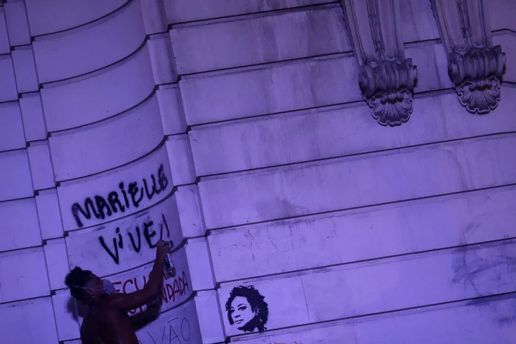 A demonstrator graffitis "Marielle lives!" as he takes part in a rally against the shooting of Rio de Janeiro city councilor Marielle Franco in Rio de Janeiro, Brazil March 16, 2018.  REUTERS/Ricardo Moraes (Ricardo Moraes/Reuters)