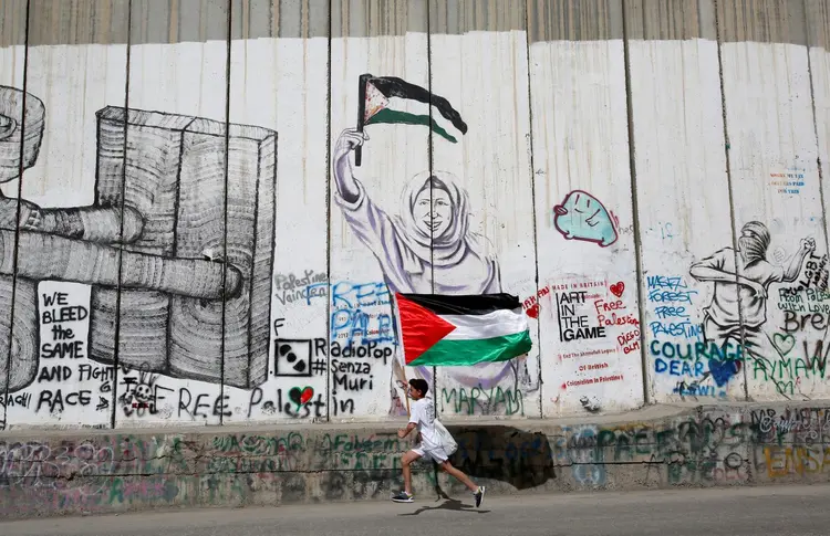 Palestino passa pela fronteira (Mussa Qawasma/Reuters)