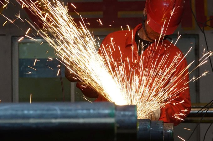 Trabalhador polindo tubos de aço (Stringer/Reuters)