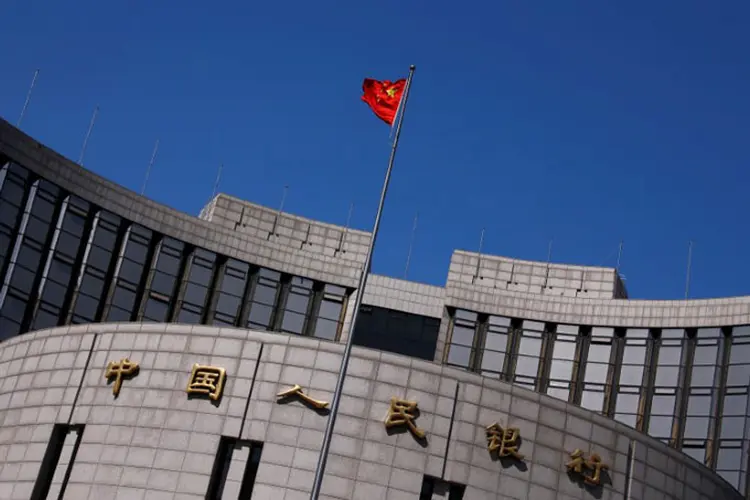 Bandeira chinesa é vista em sede do Banco Central da China: país procura reduzir o risco de uma desaceleração mais acentuada em sua economia (Petar Kujundzic/Reuters)