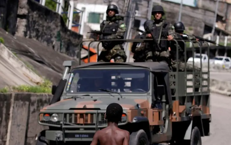 RIO DE JANEIRO: criança observa a patrulha das Forças Armadas, durante operação contra o tráfico no Rio de Janeiro / Ricardo Moraes/Reuters (Ricardo Moraes/Reuters)