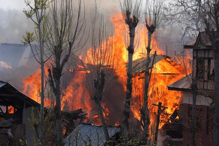 Casas pegam fogo durante conflito entre soldados e militantes na região da Caxemira, na Índia (Danish Ismail/Reuters)