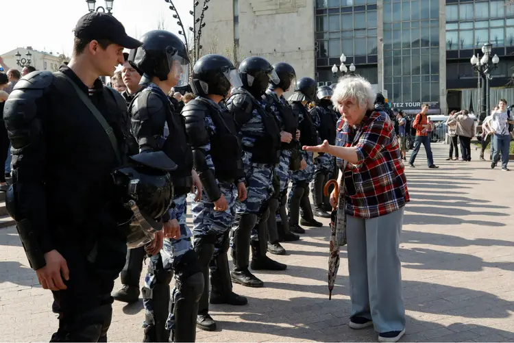 Mulher fala com policiais durante protesto:  "As prisões foram brutais", indicou organização (Tatyana Makeyeva/Reuters)