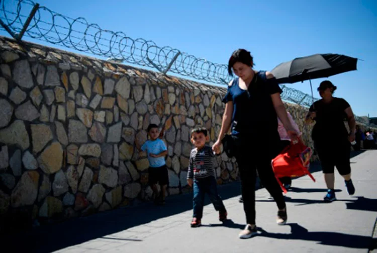 Viajantes procedentes do México cruzam, em 20 de junho de 2018, a ponte internacional Paso del Norte para entrar nos Estados Unidos em El Paso, no Texas (Brendan Smialowski/AFP)