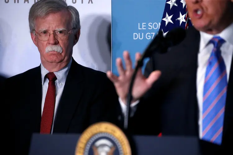 John Bolton observa Donald Trump (Leah Millis/Reuters)