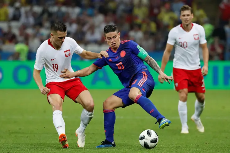 O craque colombiano James Rodriguez dribla jogadores da Polônia. (Toru Hanai/Reuters)