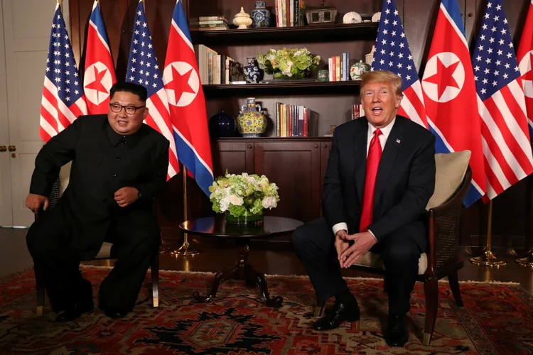 O presidente dos EUA, Donald Trump, senta-se ao lado do líder da Coréia do Norte, Kim Jong Un, antes da reunião bilateral no Hotel Capella, na ilha de Sentosa, em Singapura, em 12 de junho de 2018. REUTERS / Jonathan Ernst
 (Jonathan Ernst/Reuters)