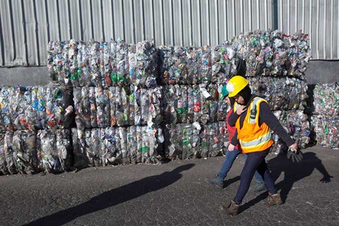 Pilhas de lixo plástico comprimido em um centro de reciclagem.