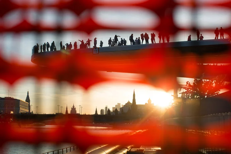 Visitantes caminham na "ponte flutuante" no parque Zaryadye para ver as torres do Kremlin no pôr-do-sol (Andrey Rudakov/Bloomberg)