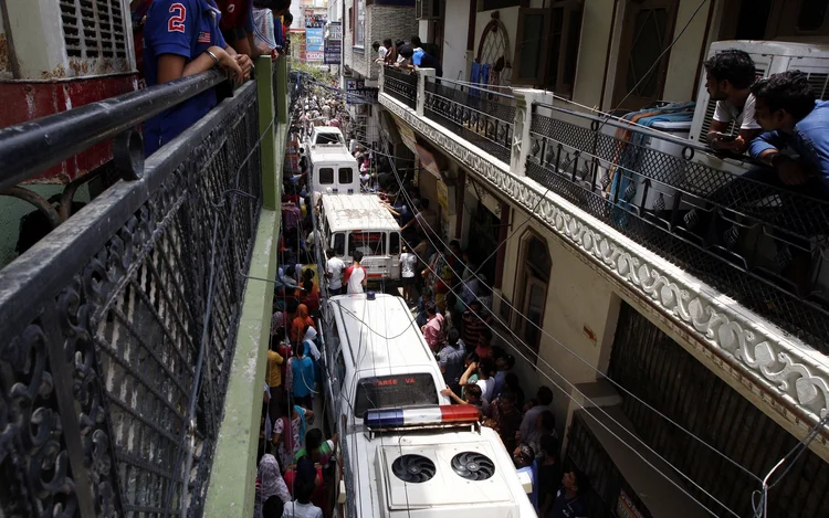 Ambulâncias aguardam para transportar os 11 corpos encontrados em casa em Nova Délhi, na Índia (Stringer/Reuters)