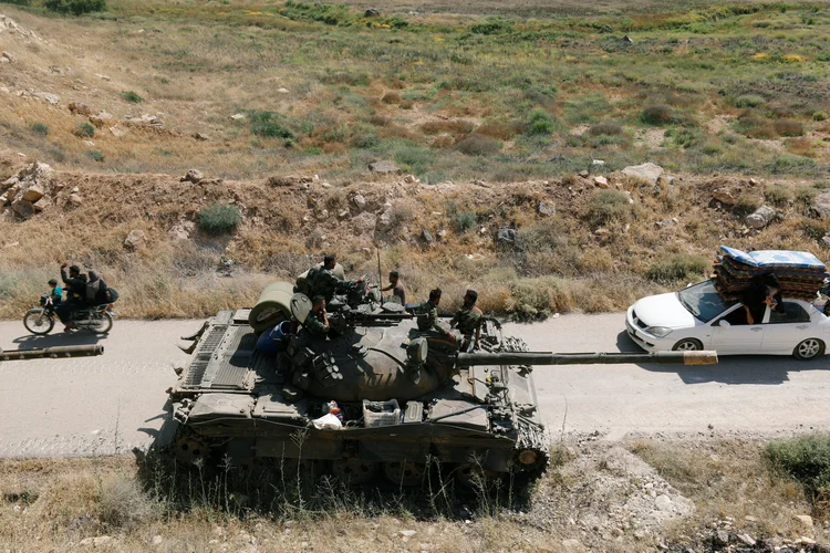 Civis passam pelo tanque das forças sírias do presidente Bashar al Assad em Deraa. 07/07/18 (Omar Sanadiki/Reuters)
