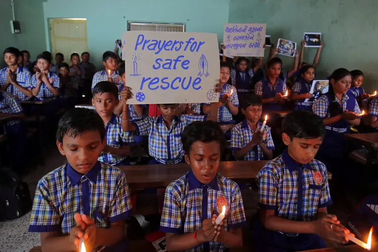 Tailândia: crianças rezam para os estudantes que estão presos dentro de uma caverna inundada. Oito meninos já foram resgatados (Amit Dave/Reuters)
