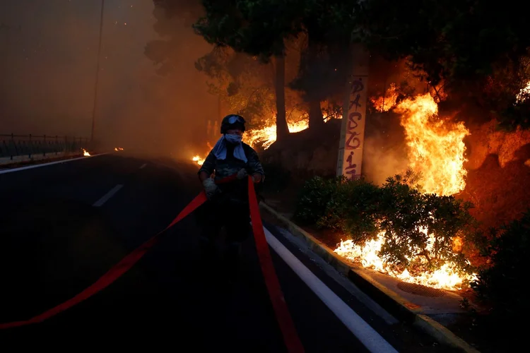 Incêndio: depois de recuperar os corpos de 24 pessoas em diferentes pontos da região, os bombeiros encontraram esta manhã um grupo de 25 pessoas (Costas Baltas/Reuters)
