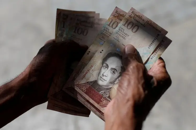 Venezuelano conta bolívares: situação no país foi comparada pelo FMI à da Alemanha de 1923 (Marco Bello/Reuters)