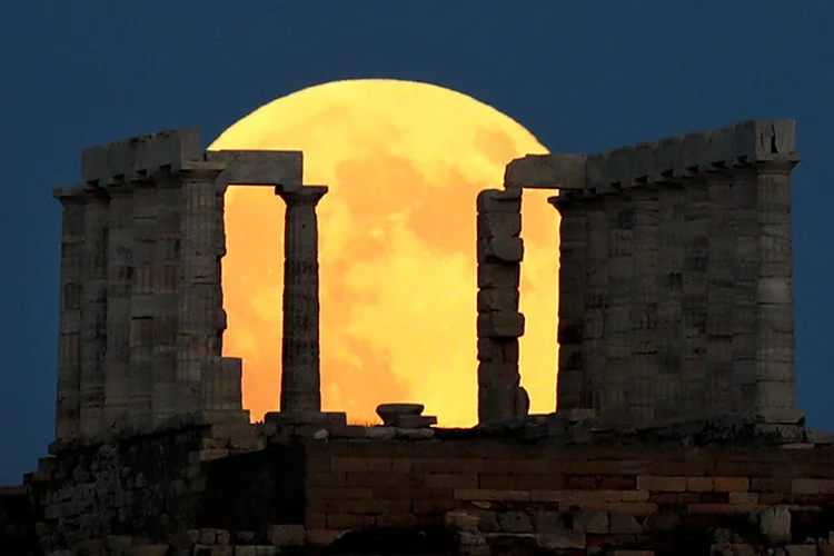 Lua cheia sobe atrás do Templo de Poseidon antes do eclipse lunar em Cape Sounion, perto de Atenas, na Grécia, em 27 de julho de 2018.  (Alkis Konstantinidis/Reuters)