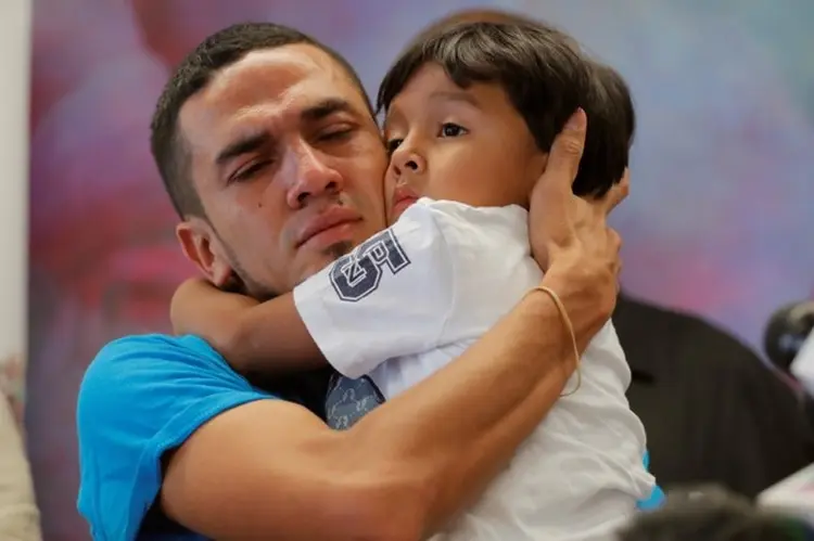 Javier, de Honduras, abraça seu filho William, de 4 anos, após serem reunidos depois de 55 dias separados na sequência de sua detenção na fronteira do México com os EUA: crianças ainda em custódia do governo são 572 (Lucas Jackson/Reuters)