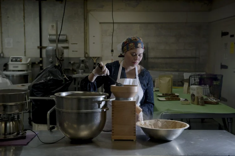 Farinha de cevada: na cozinha temporária da Rise Products, em Nova York, Bertha Jimenez prepara a farinha feita com grãos usados na fabricação de cerveja fornecidos pelas cervejarias locais (George Etheredge/The New York Times)