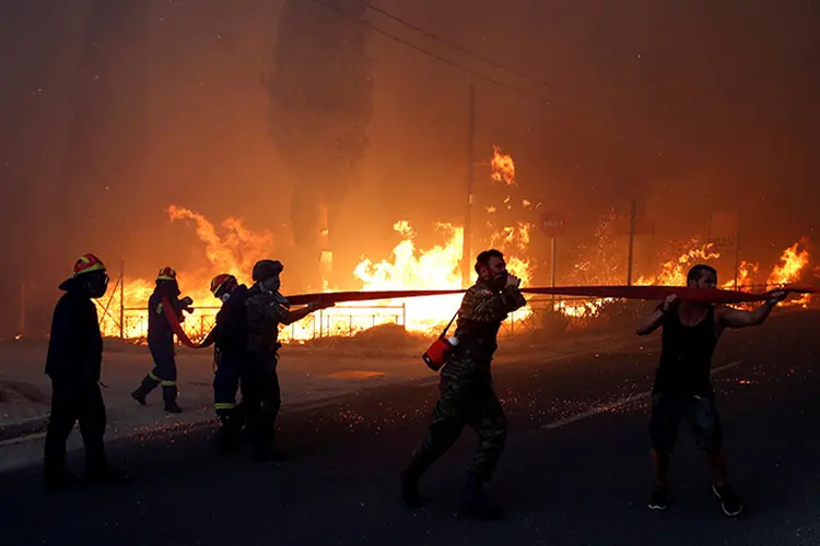 Bombeiros, soldados e moradores locais combatem incêndio em Rafina, perto de Atenas.  (Costas Baltas/Reuters)