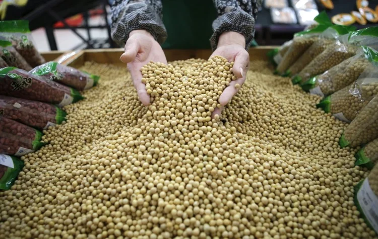 Funcionário separa grãos de soja em mercado em Hubei, na China. (Stringer/Reuters)
