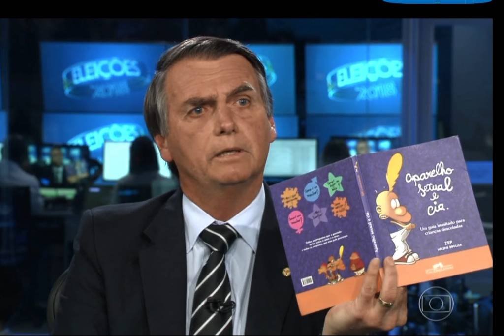 Jair Bolsonaro exibe livro da Companhia das Letras, Aparelho sexual e cia, durante o Jornal Nacional (TV Globo/Reprodução)