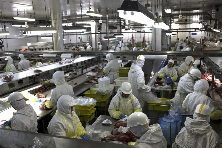 Workers process meat at the Minerva SA meat processing plant in Barretos, Brazil, on Tuesday, Aug. 20, 2012. Minerva SA, Brazil's third-largest beef producer, expects the company's net debt to fall to 2.5 times Ebitda in two years as beef plants ramp up. Photographer: Dado Galdieri/Bloomberg (Dado Galdieri/Bloomberg/Bloomberg)