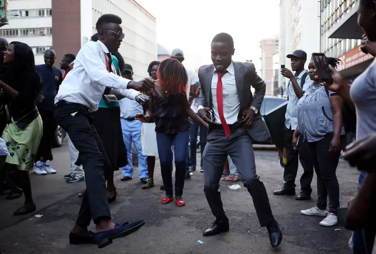Partidários do partido de oposição, MDC dançam nas ruas, mas o partido de Mugabe tem até o momento mais de dois terços dos representantes no Parlamento (Siphiwe Sibeko/Reuters)