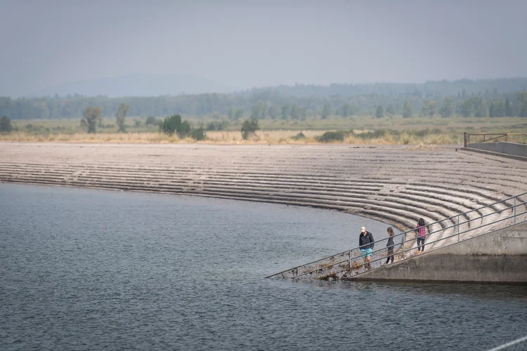 Pessoas caminham na beira do lago Jackson em Jackson Hole, no Wyoming, nos Estados Unidos (David Paul Morris/Bloomberg)