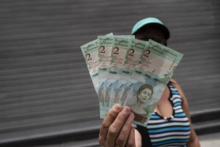 Mulher mostra novas notas do bolívar soberano em Caracas, na Venezuela (Carlos Becerra/Bloomberg)