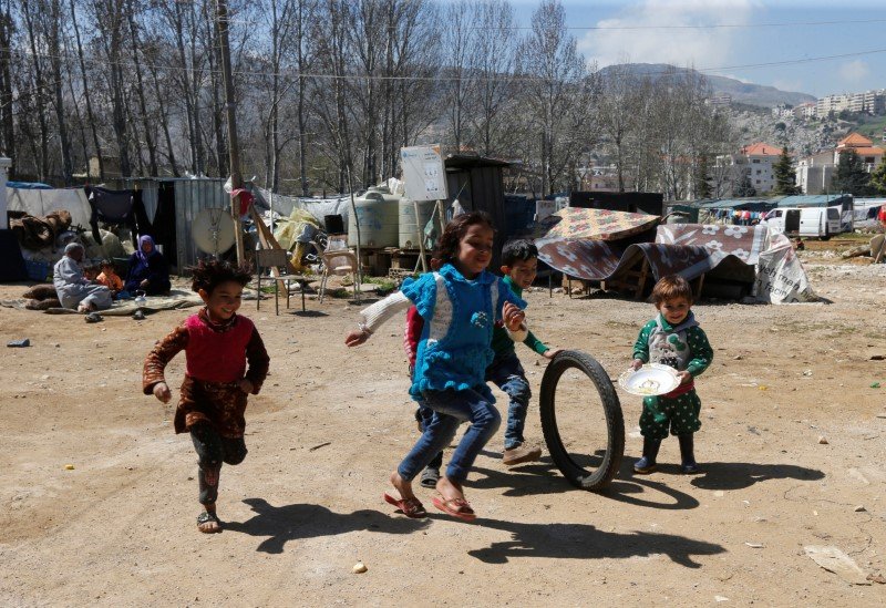 Refugiados sírios deixam o Líbano e cruzam a fronteira de volta ao país