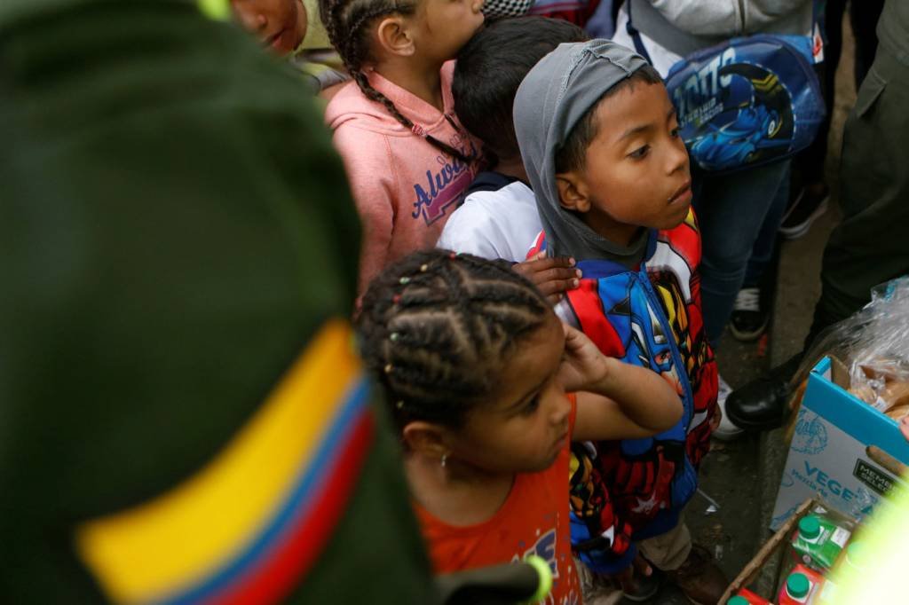 Crise econômica: filhos de imigrantes venezuelanos fazem fila para receber comida em um acampamento improvisado em Bogotá (Reuters/Luisa Gonzalez)
