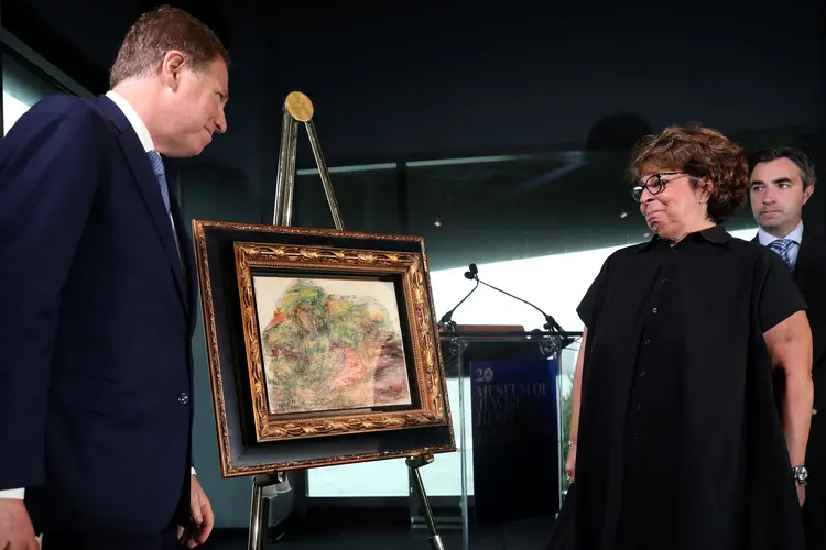 O Procurador dos EUA Geoffrey S. Berman e Sylvie Sulitzer: a pintura Deux Femmes Dans Un Jardin, de Renoir, é devolvida para a herdeira da obra em cerimônia no Jewish Heritage Museum em NY (Mike Segar/Reuters)